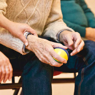 Younger hand holding elderly hand.